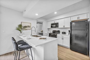 A kitchen with a white countertop and black appliances.